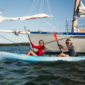 a group of people riding on the back of a boat in the water