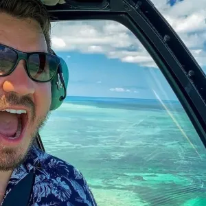 a man wearing sunglasses driving a car